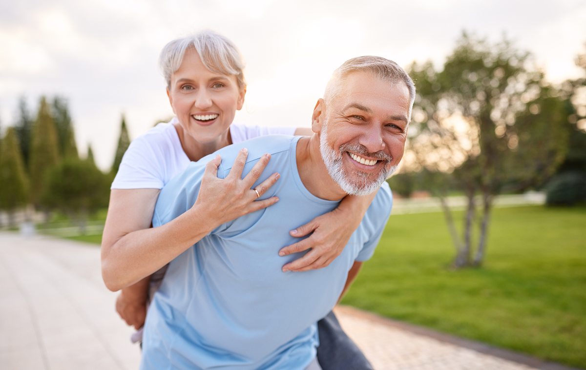Smiling senior couple outdoors showing vitality and strength, highlighting Emsculpt NEO benefits for aging muscles.