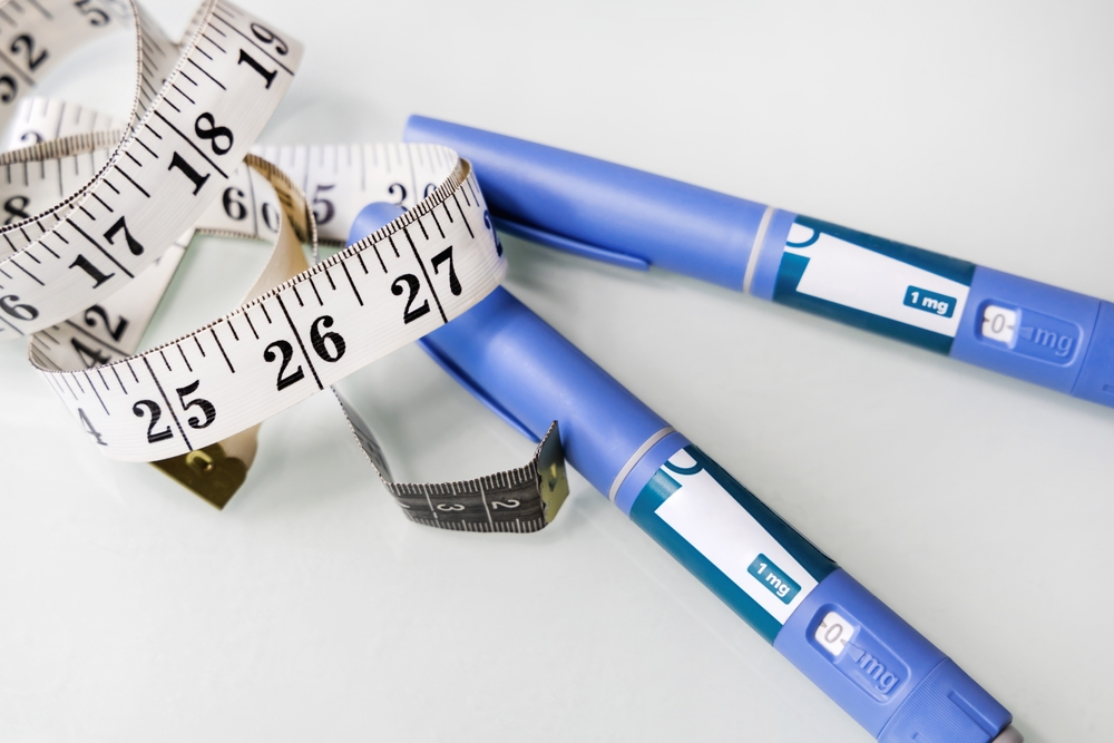 Semaglutide injection pens with measuring tape, representing medication pricing strategy and impact on weight loss treatment costs.