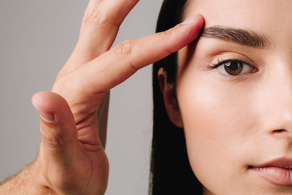 Close-up of a woman with smooth forehead and lifted brows after Botox treatment, showcasing wrinkle-free results.