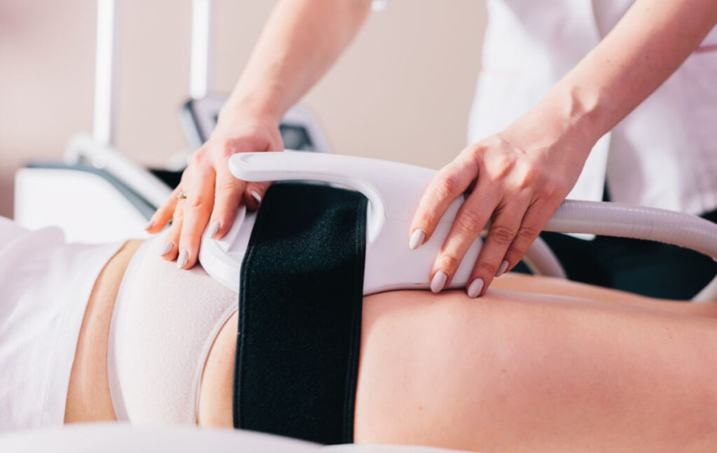 Close-up of Emsculpt Neo device applied to a patient's abdomen during non-invasive body contouring treatment.