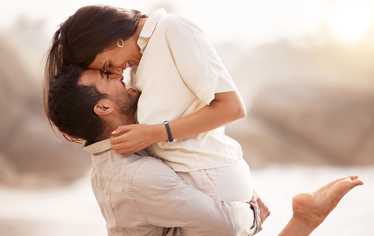 Happy couple embracing on beach, symbolizing improved intimacy and sexual wellness through off-label Botox use.