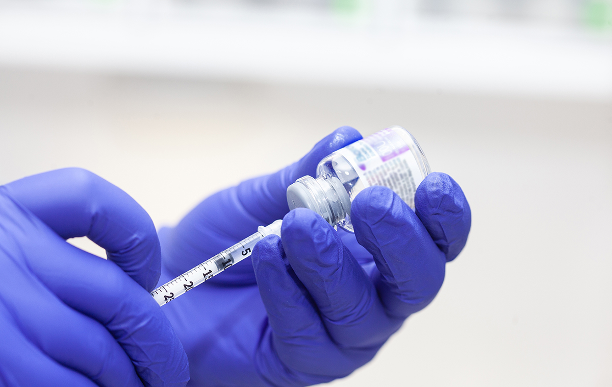 Close-up of gloved hands drawing Botox into syringe, highlighting its medical and cosmetic versatility.