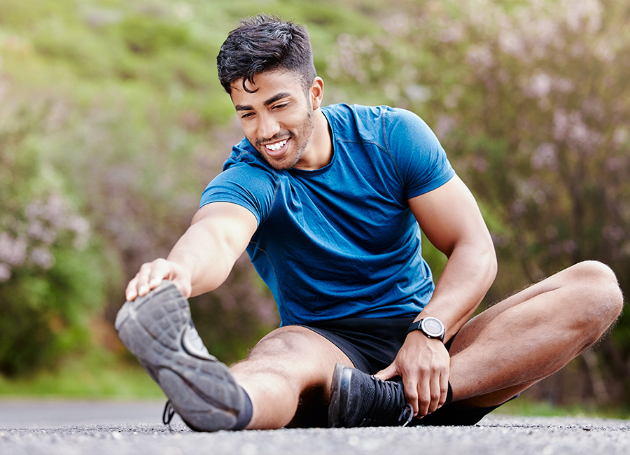 Fit man stretching outdoors in athletic wear, symbolizing benefits of testosterone therapy for male vitality and health