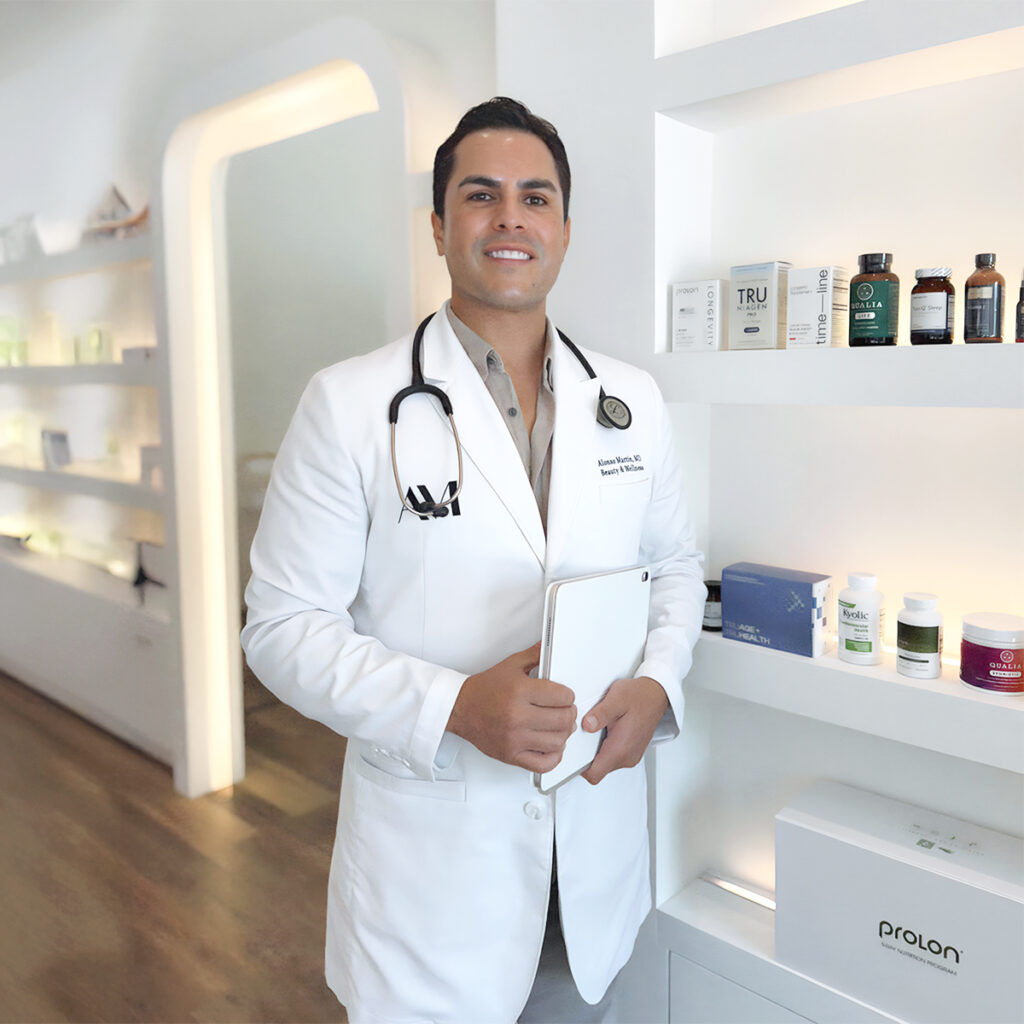 Dr. Alonso Martin at BODYWELLE in Miami Beach standing near shelves with wellness and longevity-focused health products.