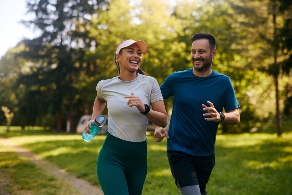 Active couple jogging outdoors representing improved vitality and well-being through genetic longevity therapies in Miami.
