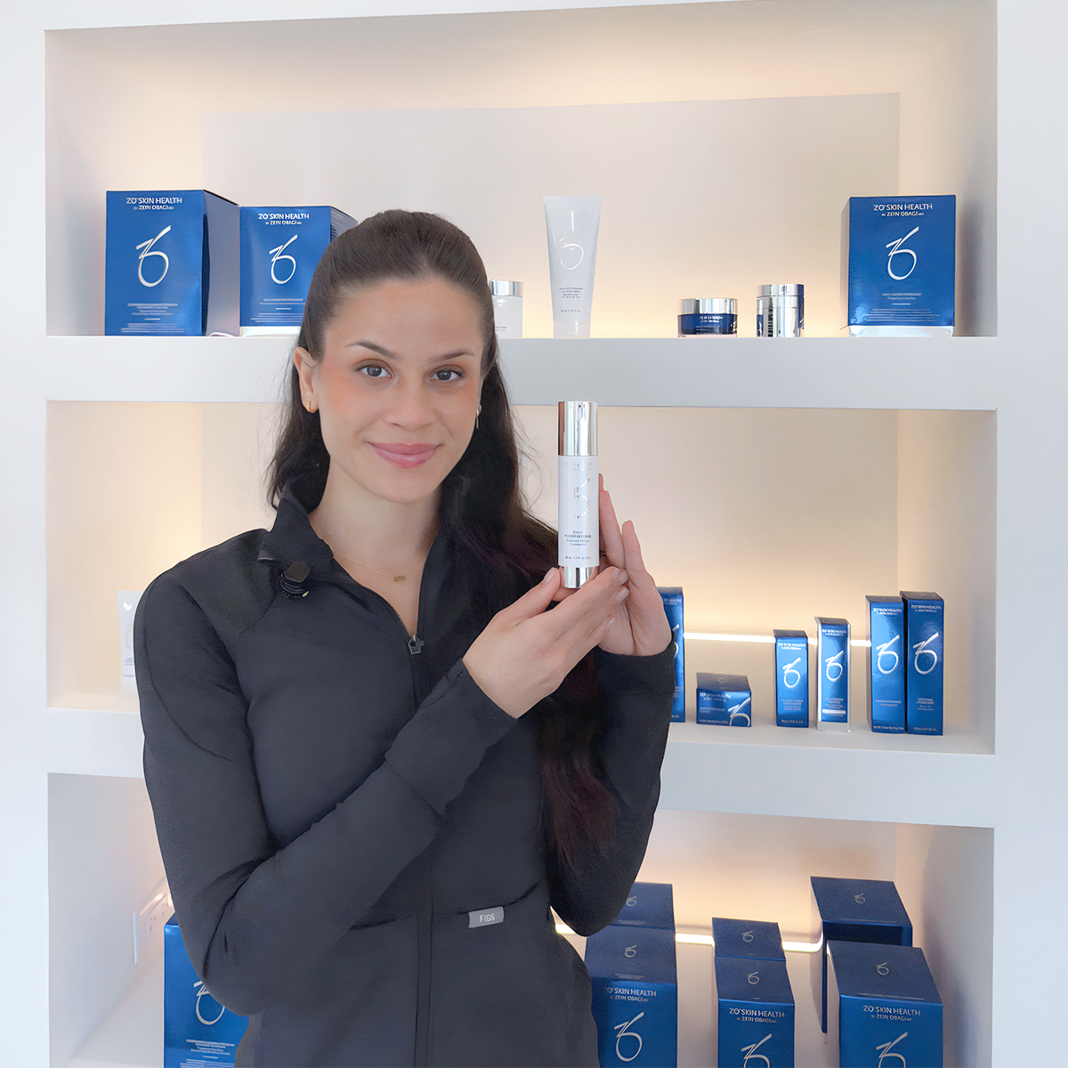 Smiling woman holding skincare product in clinic, highlighting Botox aftercare tips for longer-lasting results.