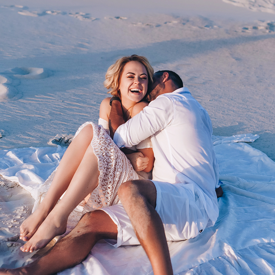 Happy couple embracing on beach at sunset, representing increased intimacy and desire supported by libido peptides