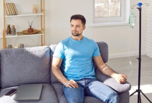 Man receiving NAD+ IV therapy at home to support energy, cognitive function, and healthy aging through cell repair.