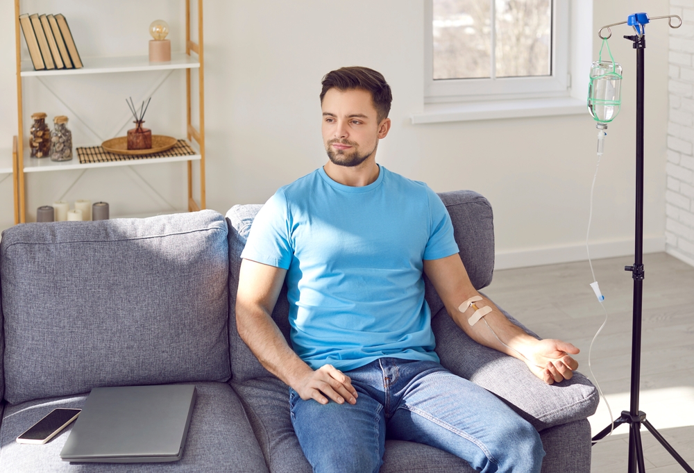 Man receiving NAD+ IV therapy at home to support energy, cognitive function, and healthy aging through cell repair.