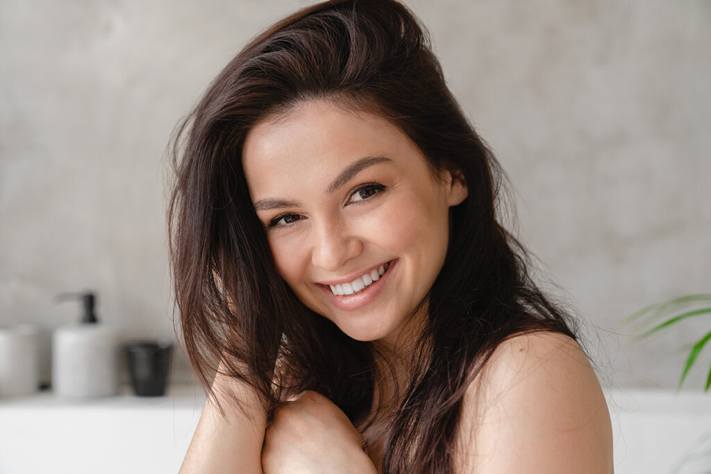 Smiling woman with youthful, glowing skin, representing an ideal candidate for a PDO thread lift treatment