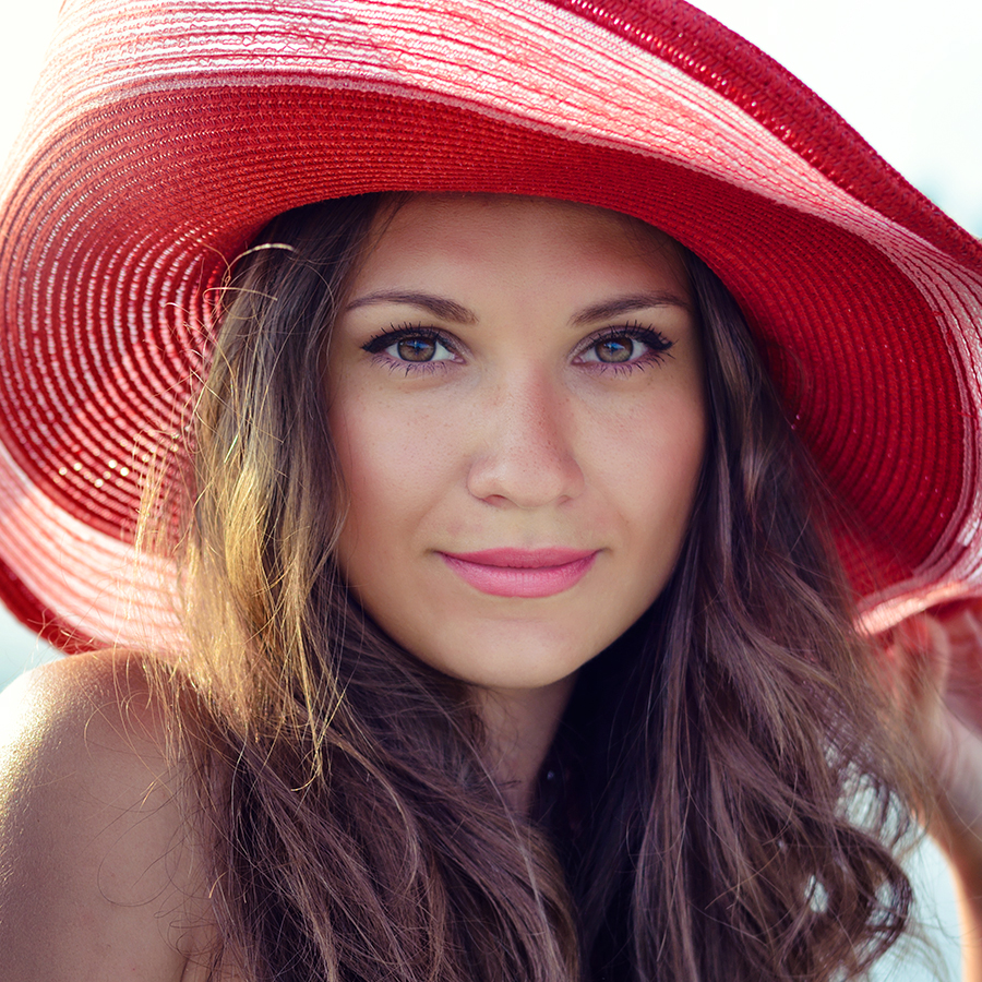 Woman with radiant skin wearing red hat, symbolizing confidence after personalized mesotherapy consultation at BODYWELLE