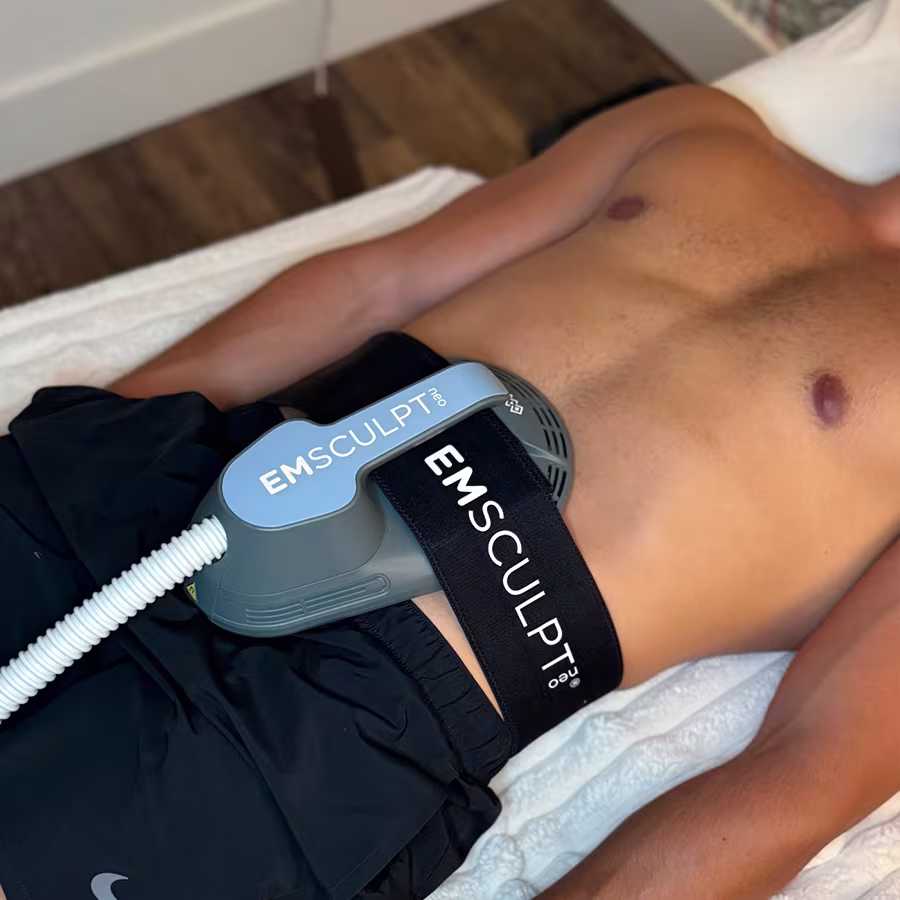 Man receiving EMSculpt NEO abdominal treatment to reduce fat and enhance muscle definition while lying on table
