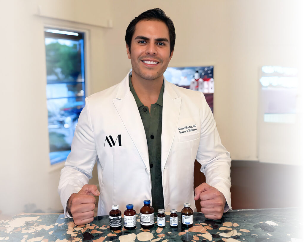 Smiling doctor at BodyWelle in Miami standing behind vials used for safe, medically supervised energy IV therapy.