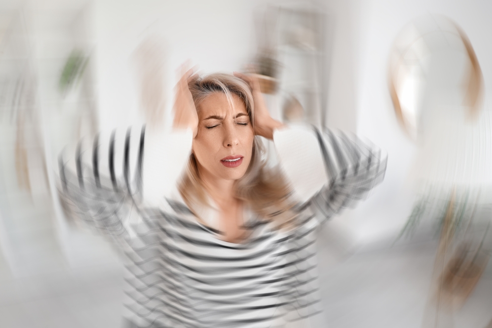 Woman holding head with blurred motion effect, symbolizing brain fog, cognitive decline, and mitochondrial dysfunction symptoms