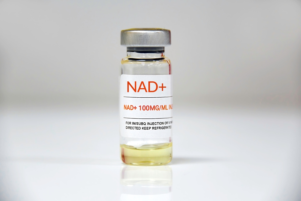 NAD+ vial on clean surface representing cellular energy support, DNA repair, and anti-aging therapy benefits