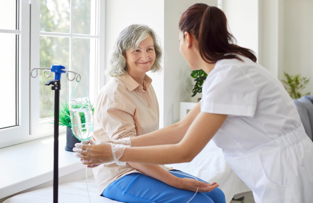 Patient receiving IV stem cell infusion from healthcare provider, illustrating systemic regenerative therapy and inflammation targeting