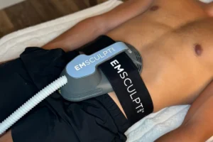 EMSculpt NEO applicator positioned on a patient’s abdomen during treatment.