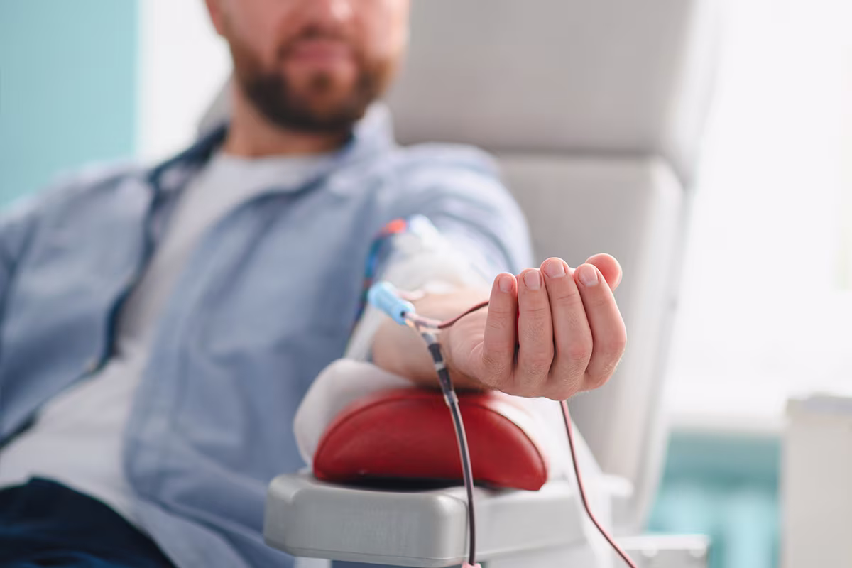 Close-up of blood-filled tubing connected to a patient’s arm.
