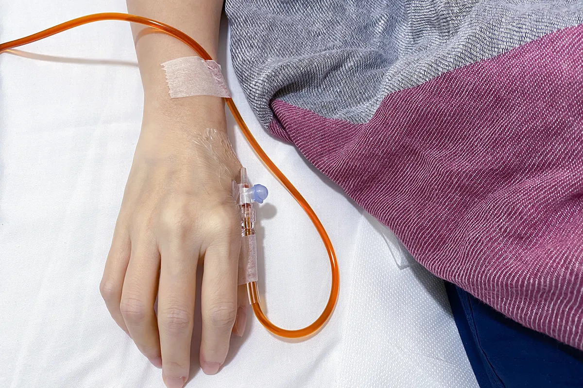 IV infusion line connected to a patient’s hand.