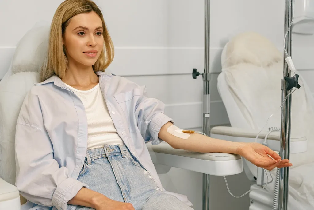 Patient receiving an IV infusion in a medical treatment chair.