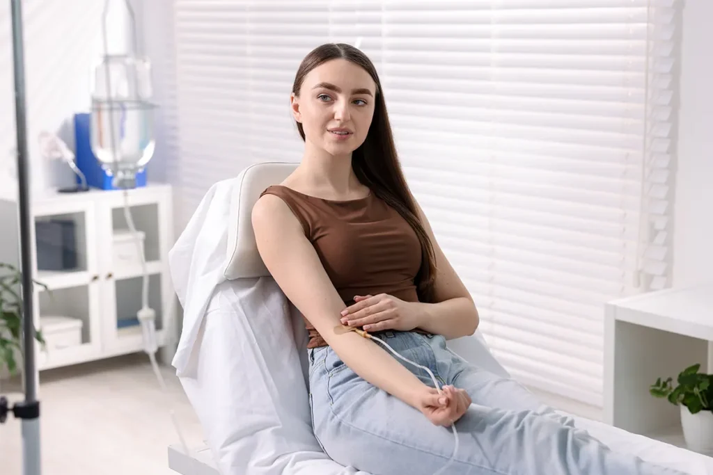 Patient seated comfortably while receiving an IV treatment in a clinic.