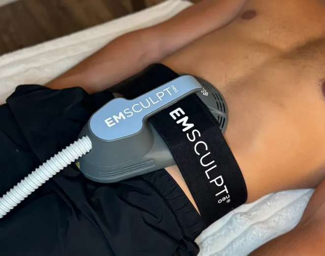 EMSculpt NEO applicator positioned on a patient’s abdomen during treatment.